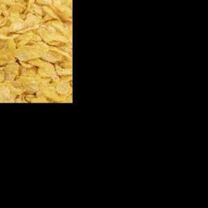 Eine Nahaufnahme einer großen Menge goldgelber Cornflakes, die die gesamte Bildfläche füllen und eine knusprige Textur zeigen.